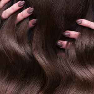 a closeup view of a bunch of shiny curls brown hair